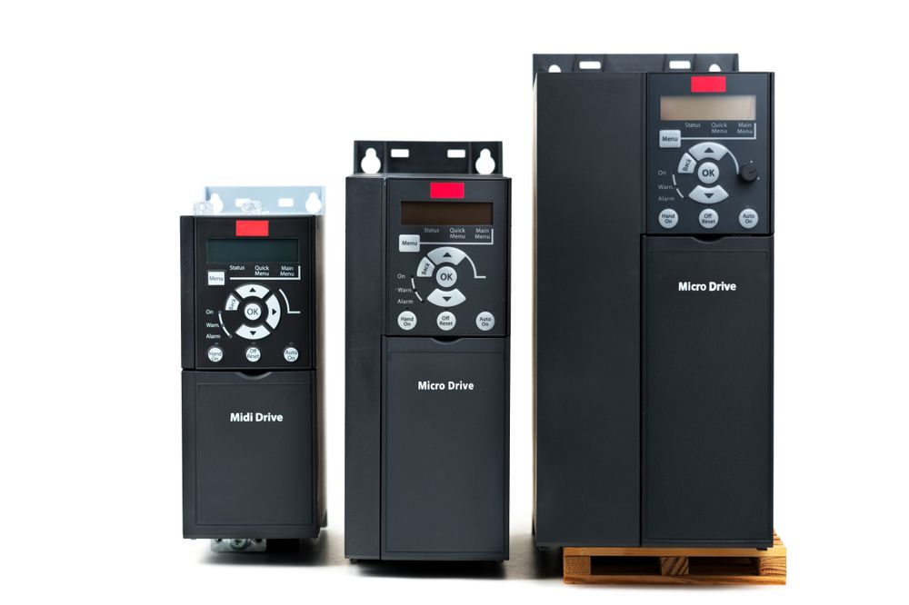Three different sizes of electrical drives are sitting on a wooden pallet.