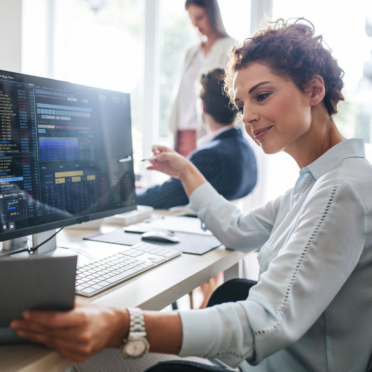 broker in front of her computer looking at stocks, her firm benefits from UPS for Financial Services & Insurance Providers