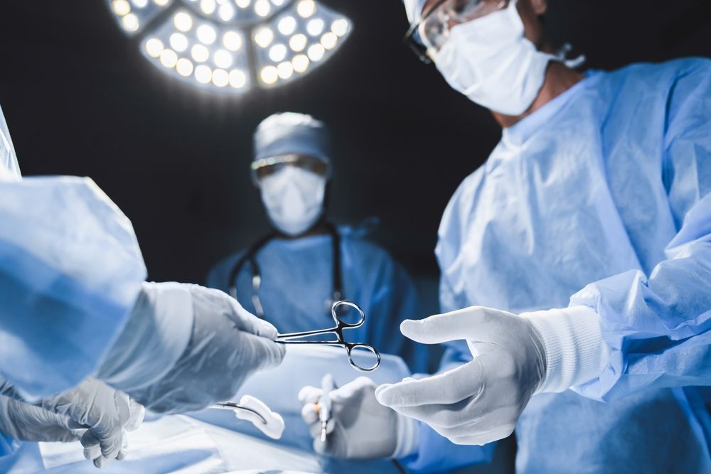 A group of surgeons are operating on a patient in an operating room.