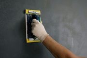 A person is using a trowel to plaster a wall.