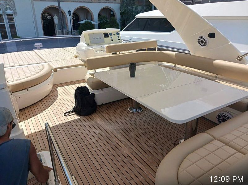 A man is sitting on the deck of a boat at 12:09 pm