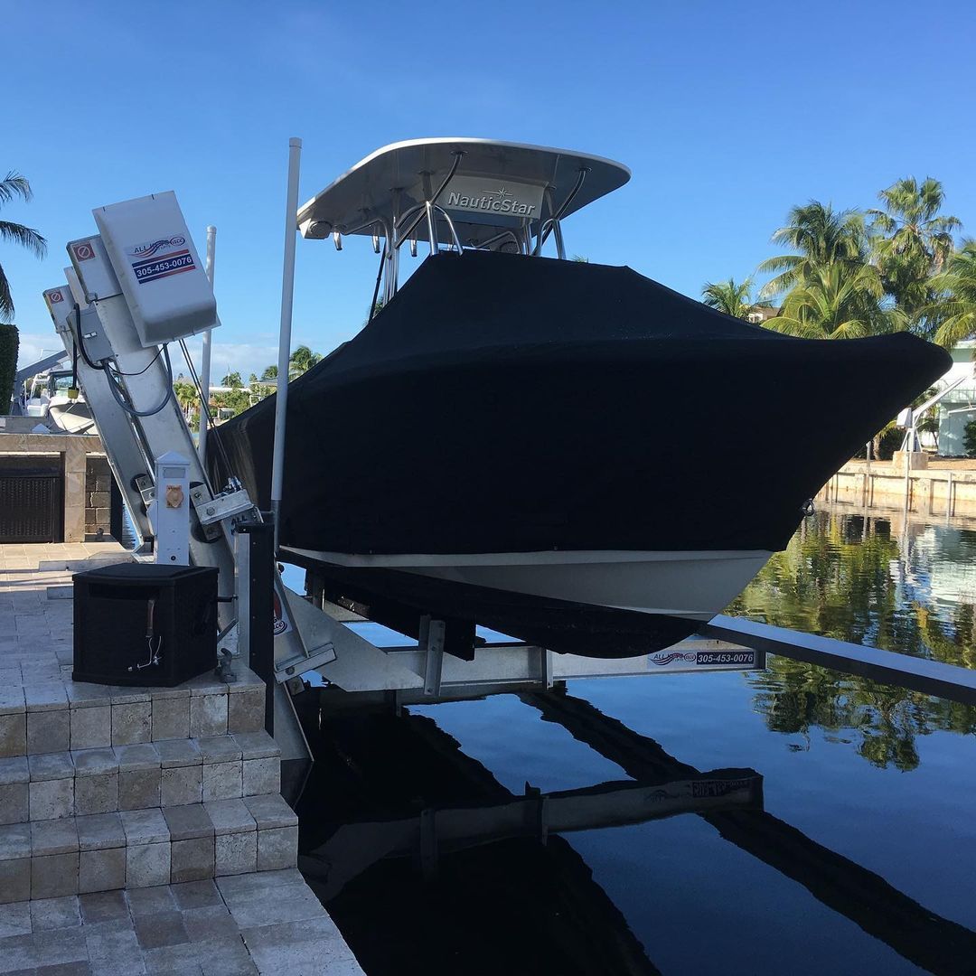 A boat is sitting on a lift next to a body of water