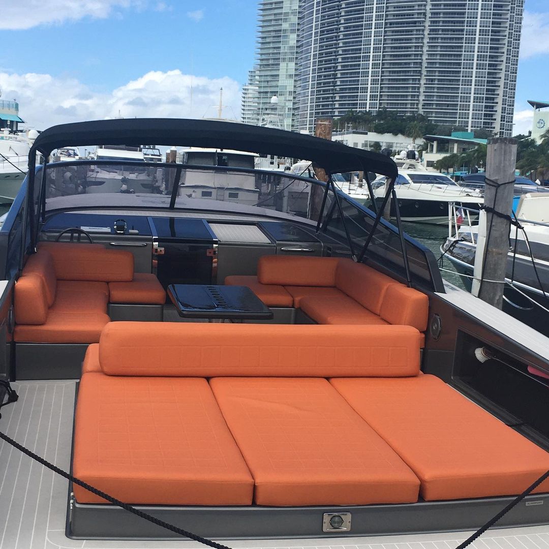 A boat with orange cushions and a black canopy