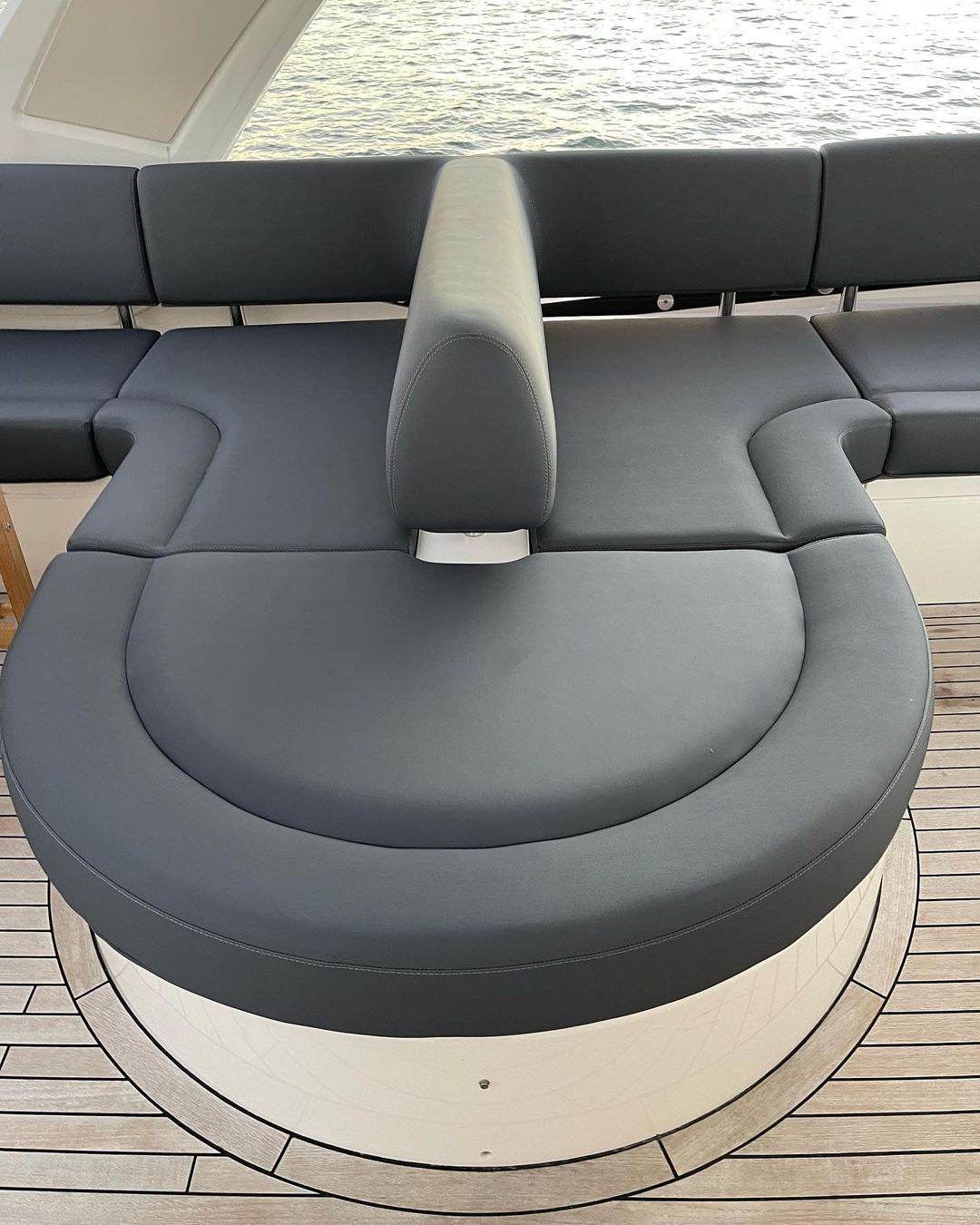 A round couch on a boat with a view of the water.