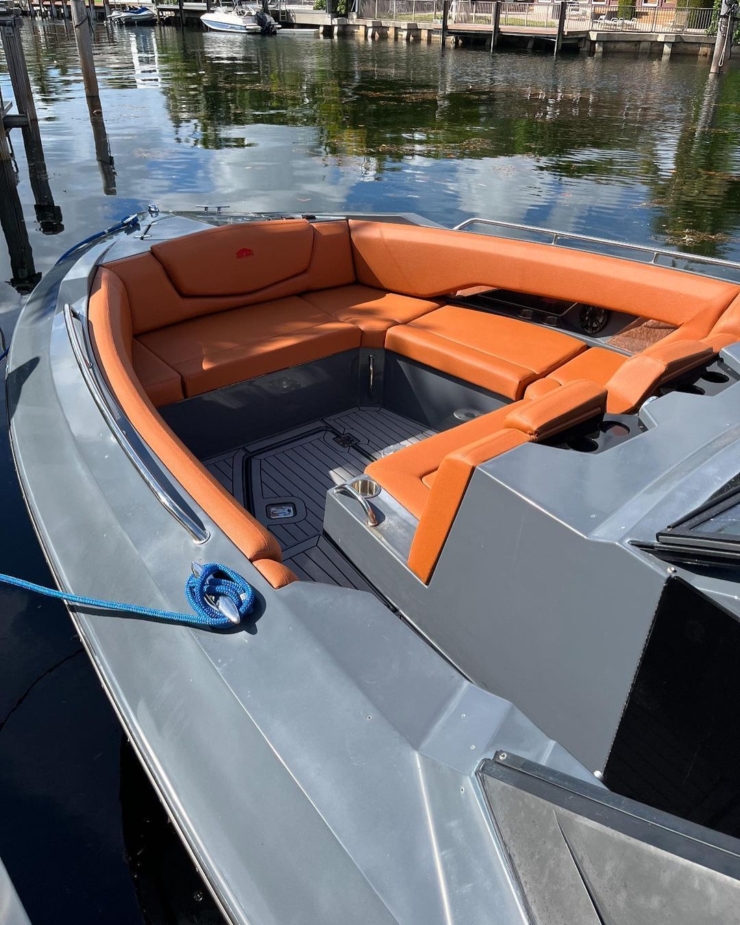 A boat with orange seats is docked in the water.