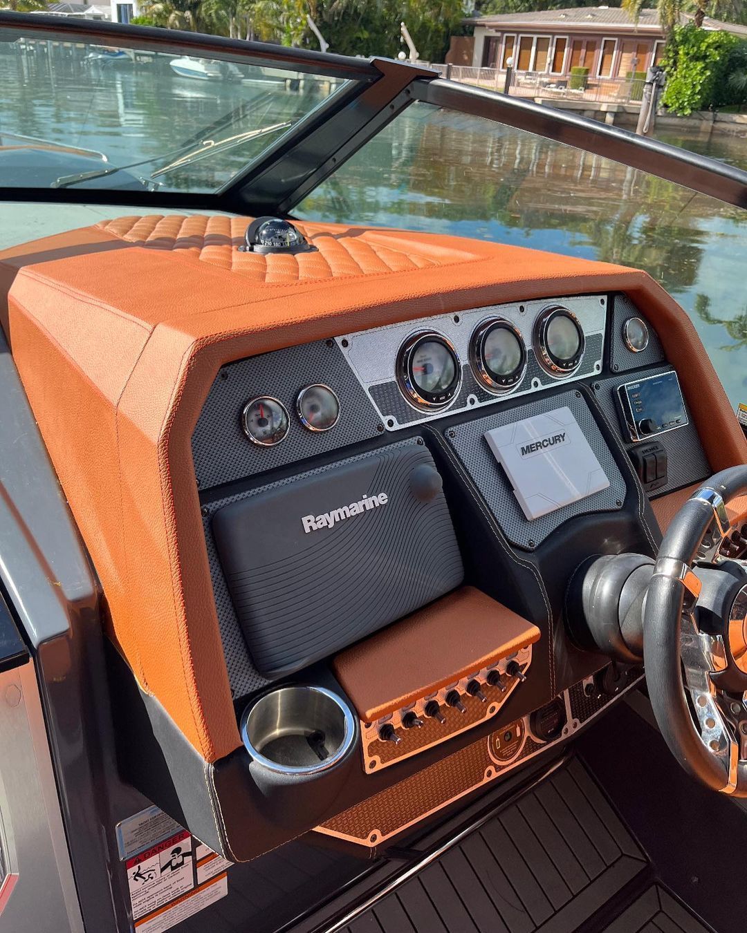 The interior of a boat with a steering wheel and dashboard.