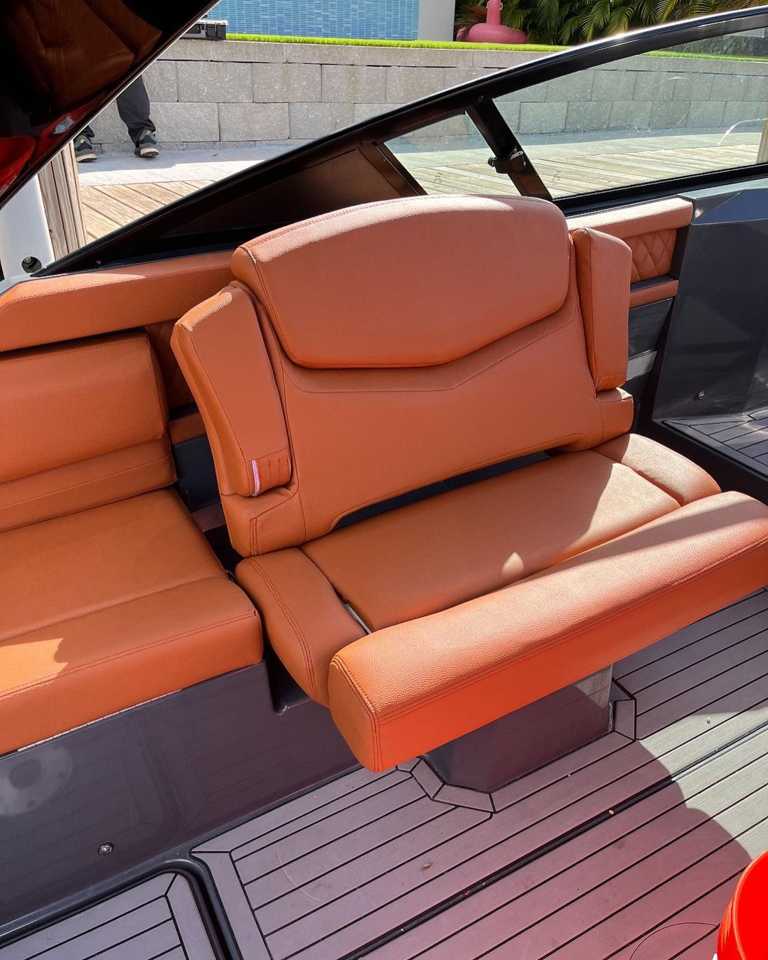 A boat with orange seats and a red bucket on the deck.