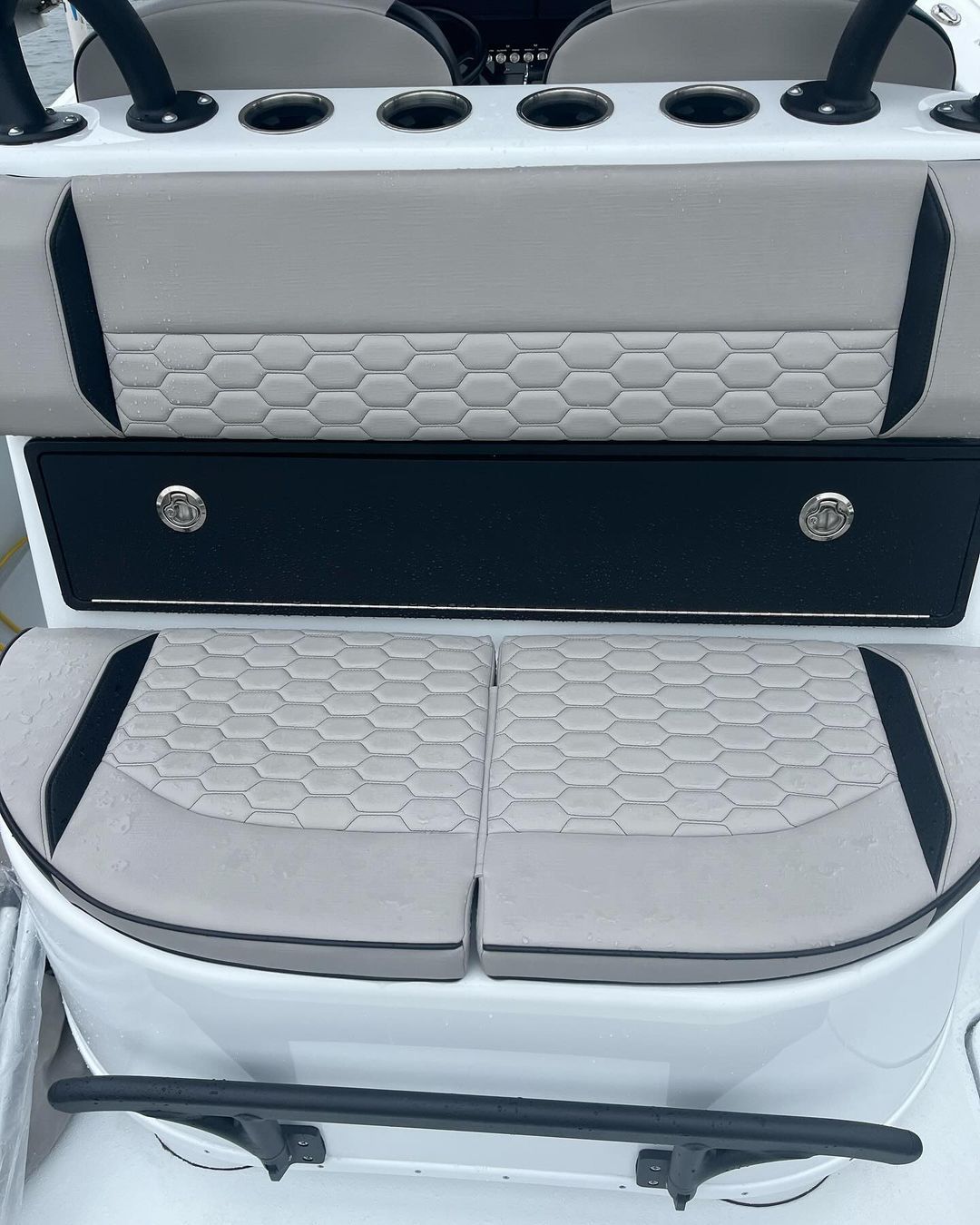 The back seat of a boat with a cushion on it.