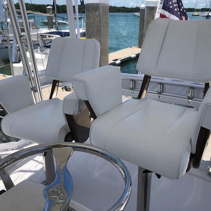 A couple of white chairs sitting on top of a boat.