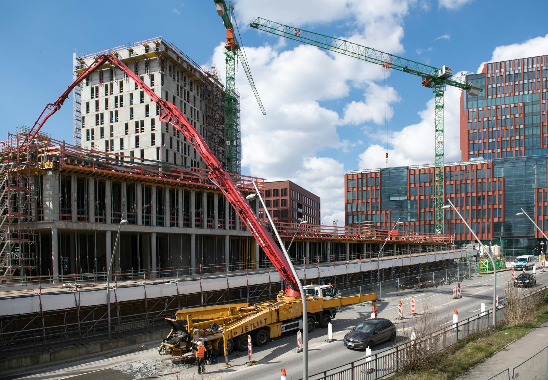 A construction site with a lot of cranes in the background