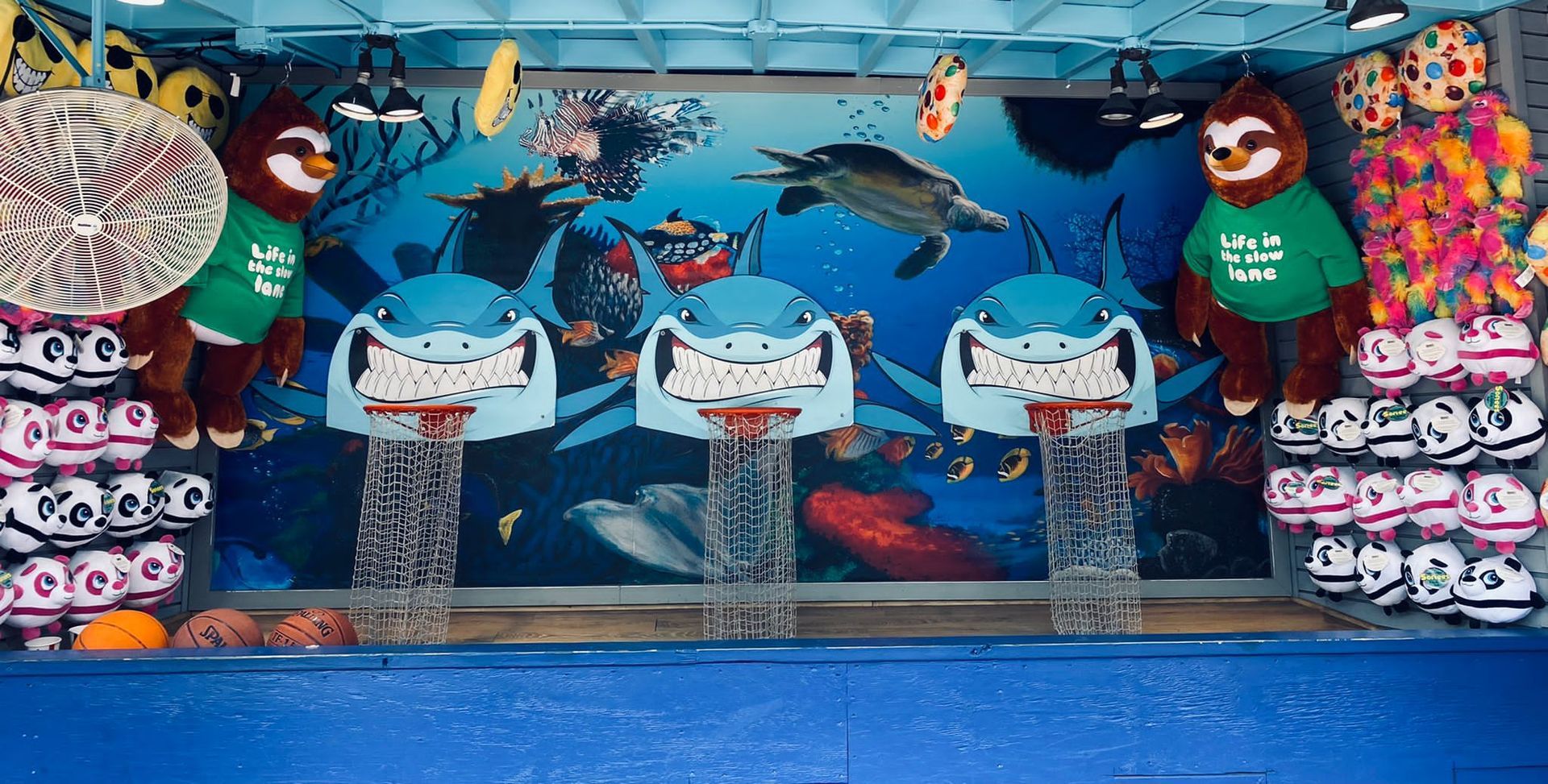 A sloth plushy wearing a green shirt with the number 3 on it at a game