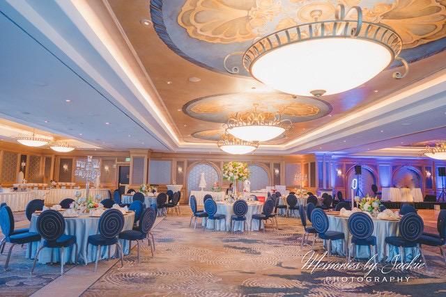 A large room with tables and chairs set up for a wedding reception.