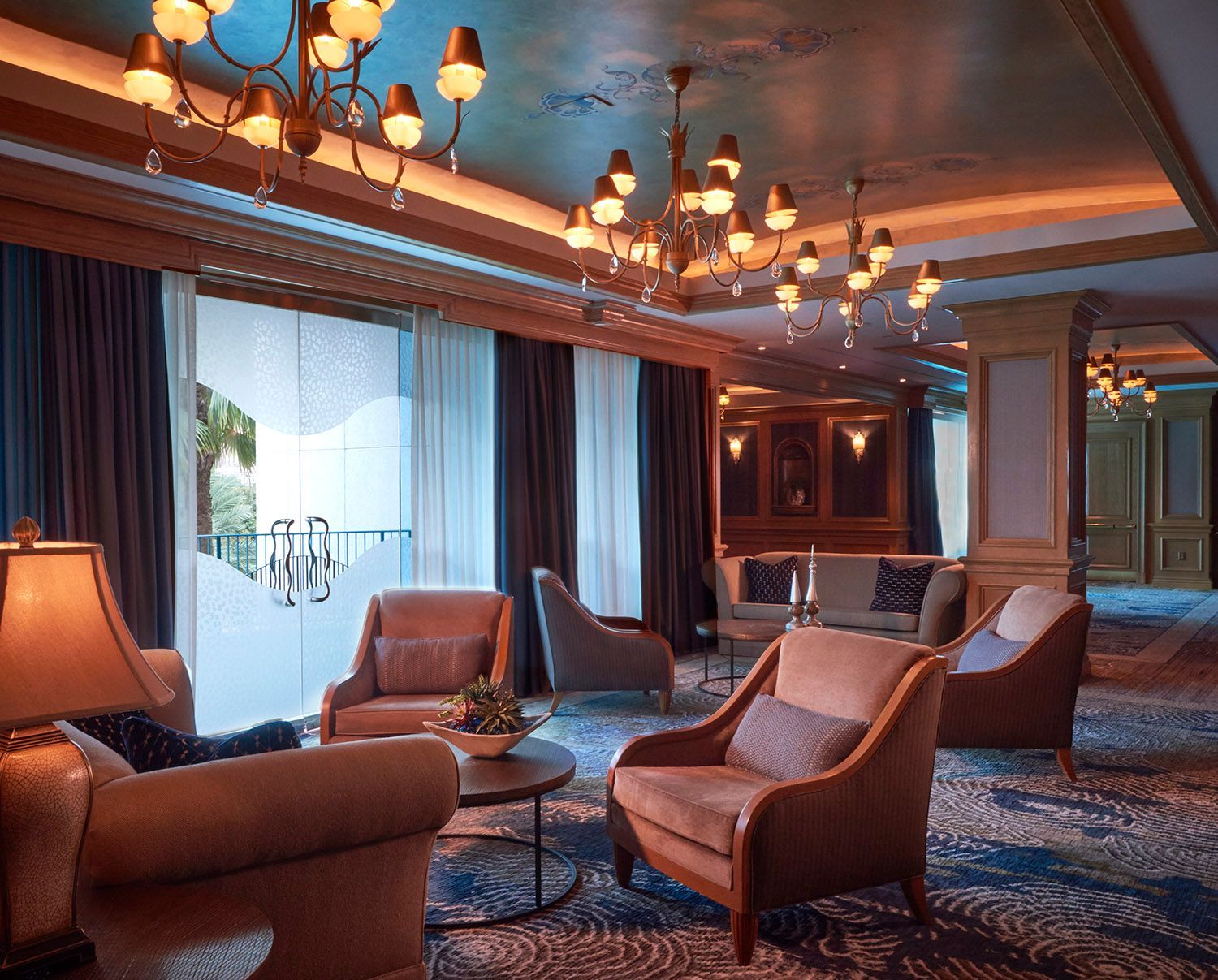 A lounge room with lots of chairs and lamps