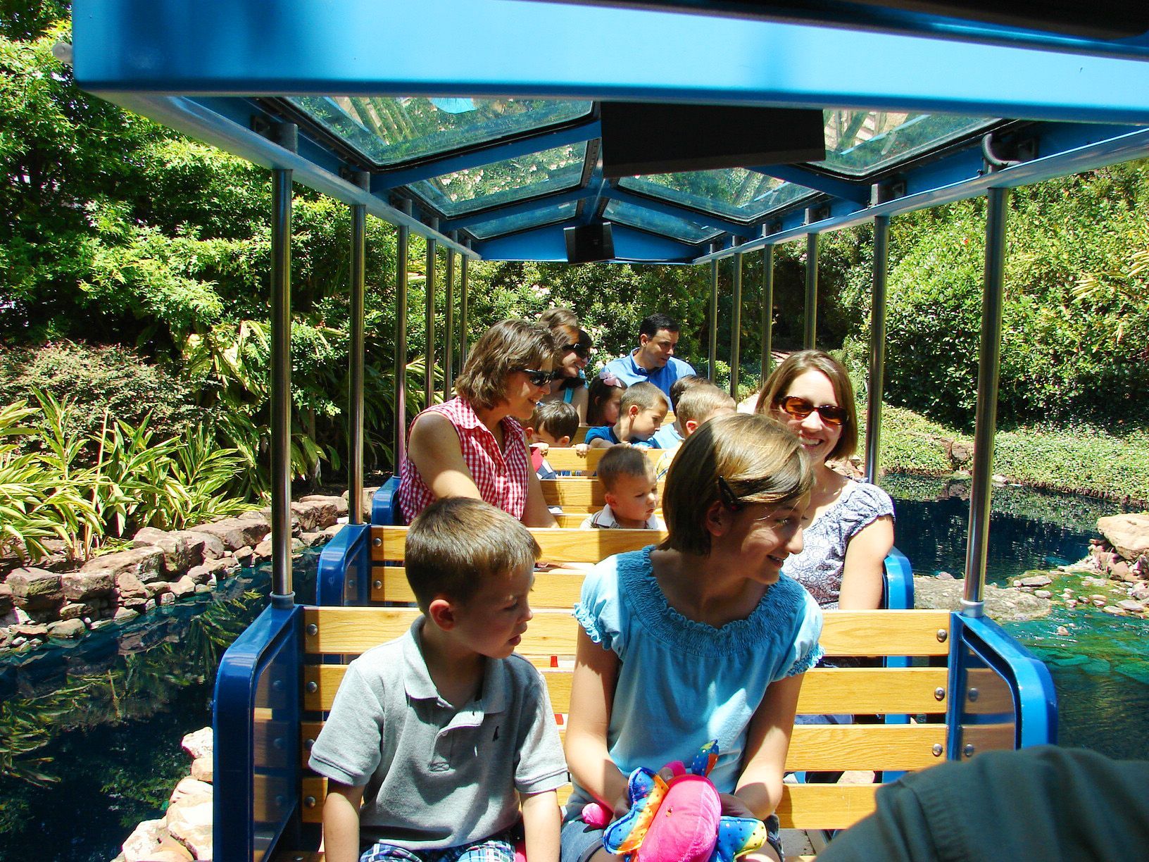 A group of people are riding on a blue train