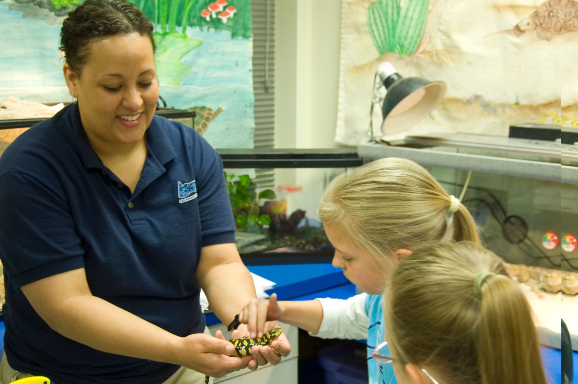 A woman wearing a blue shirt with the word zoo on it