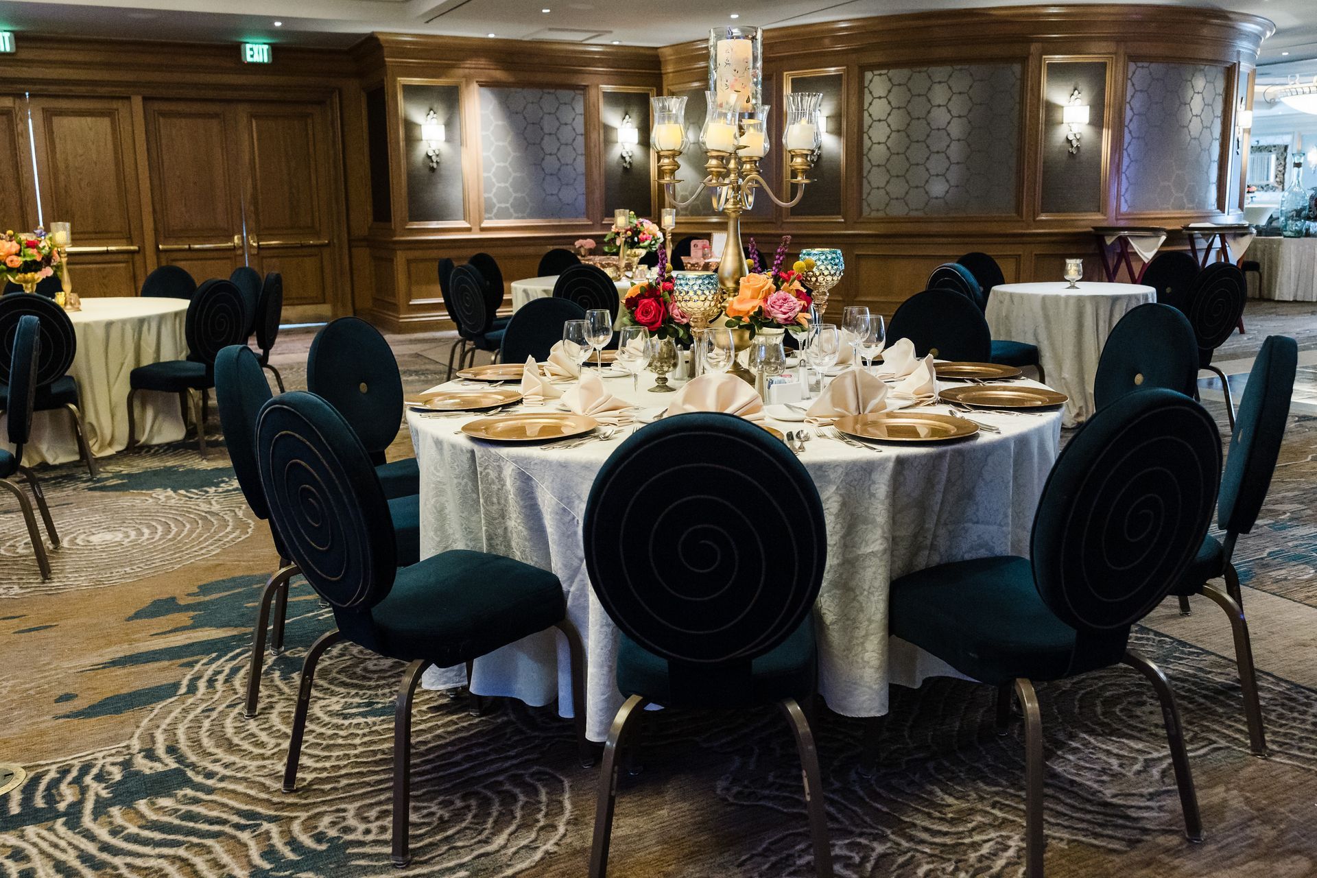 A large room with tables and chairs set up for a wedding reception