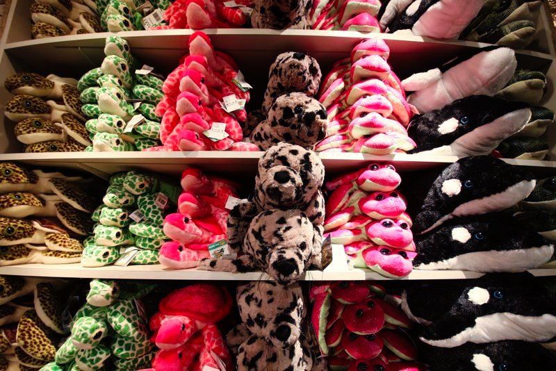 A shelf full of stuffed animals including a dalmatian