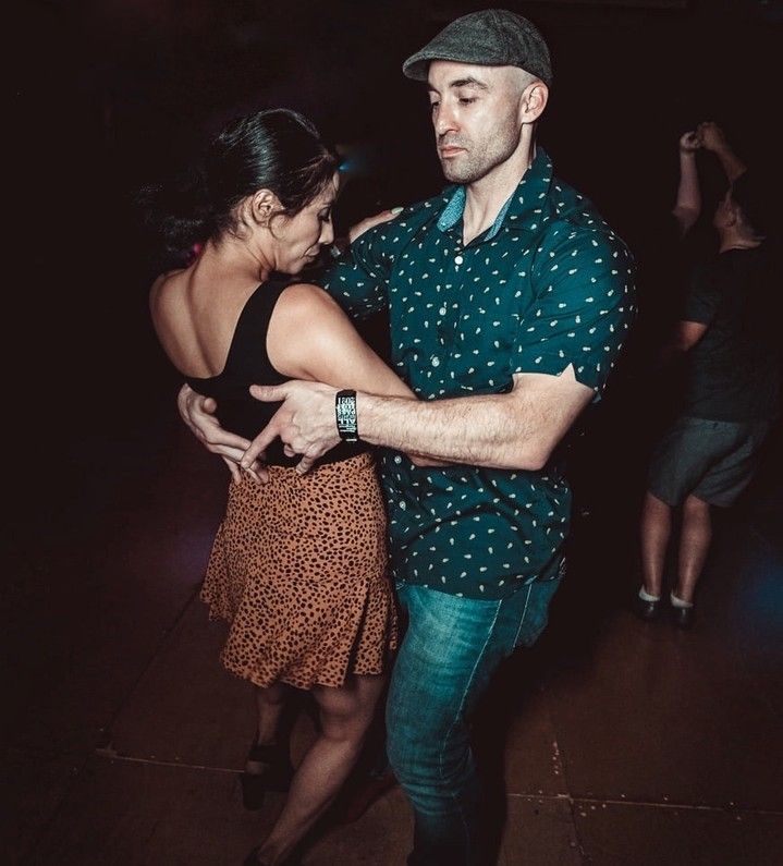 A man and a woman are dancing together in a dark room