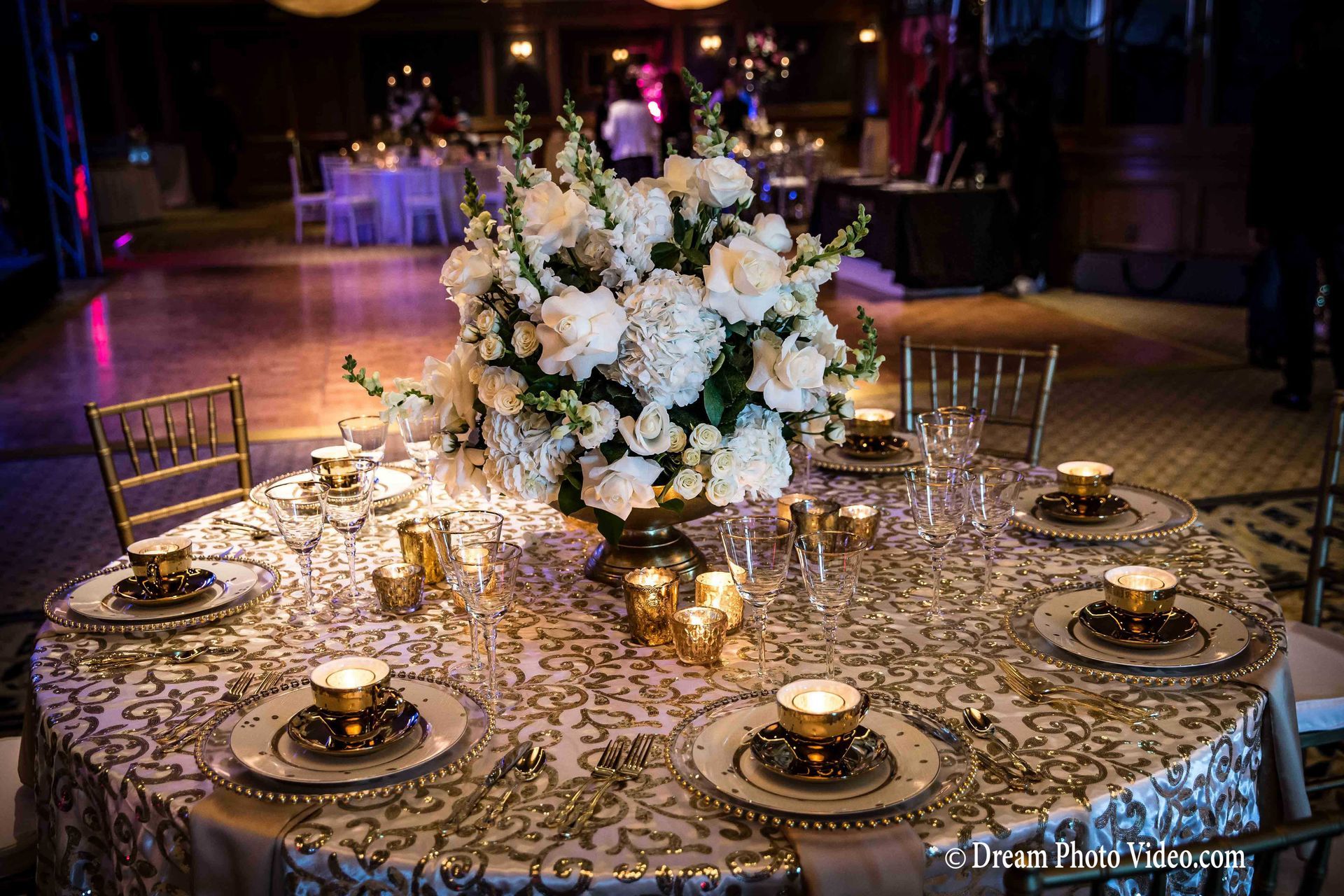 A table with a vase of white flowers on it