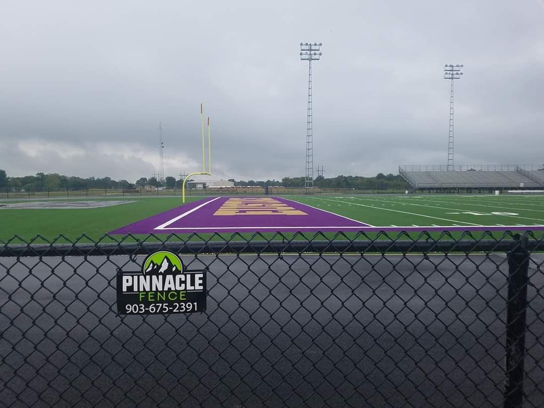 A fence with a pinnacle fence sign on it