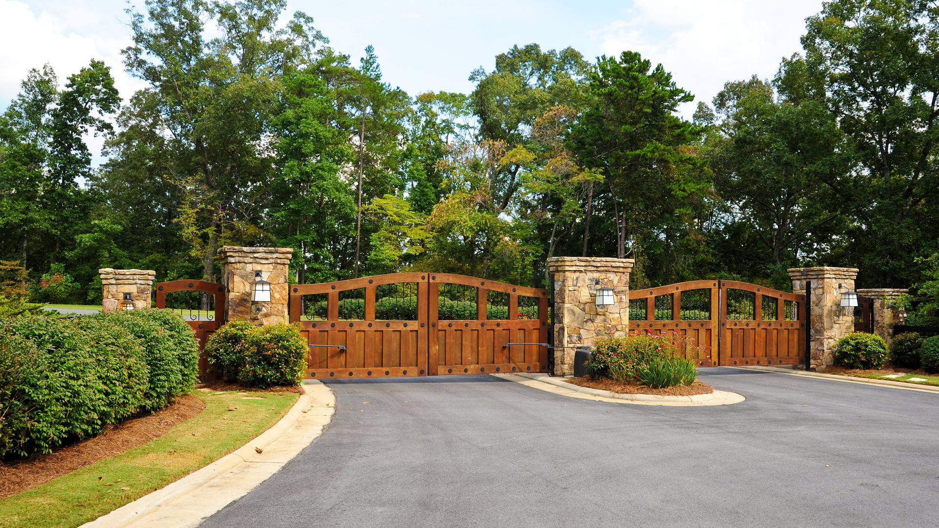 A wooden gate is surrounded by trees and bushes