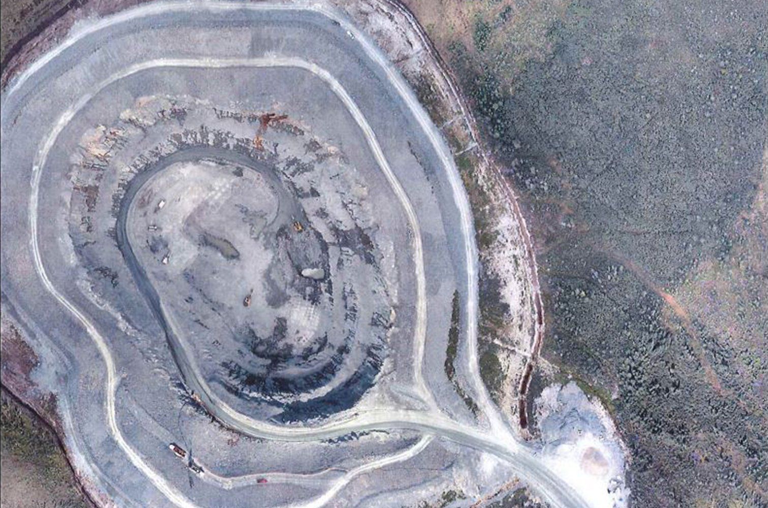 Une vue aérienne d'une grande formation rocheuse traversée par une route.