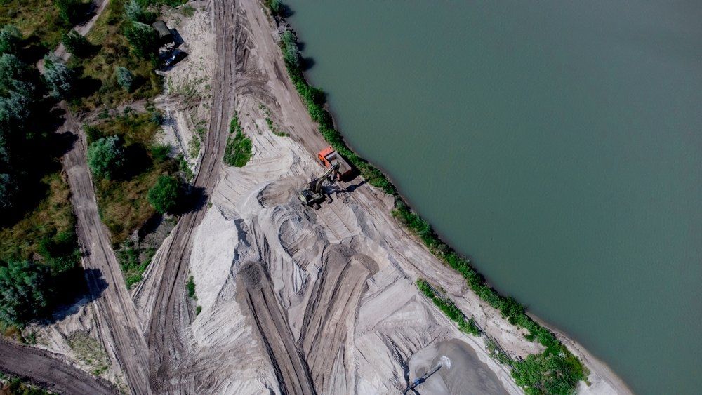 Une vue aérienne d'un chantier de construction à côté d'un plan d'eau.