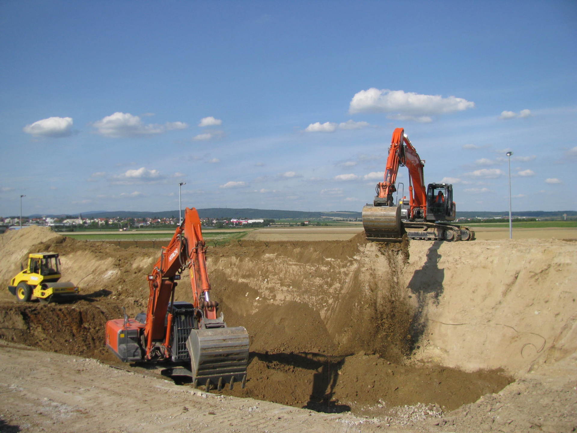 Zwei Bagger graben ein Loch in die Erde