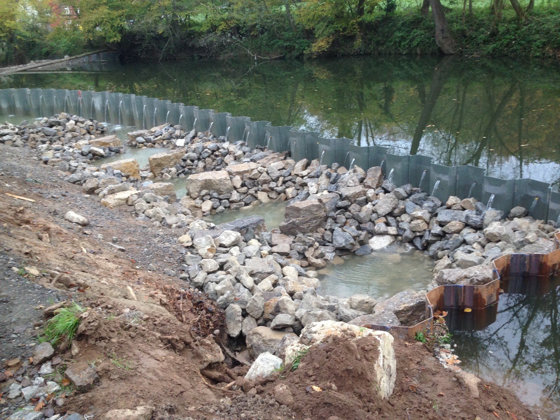 Ein Fluss mit vielen Felsen und einem Zaun darum herum