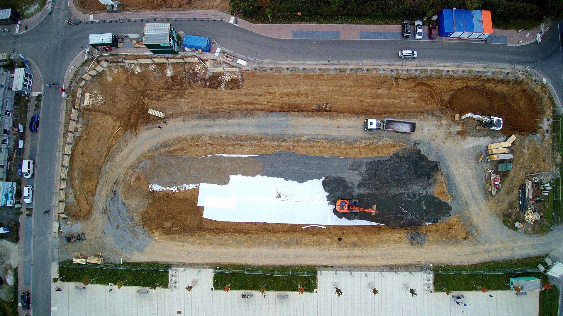 Eine Luftaufnahme einer Baustelle mit viel Schmutz und Lastwagen.