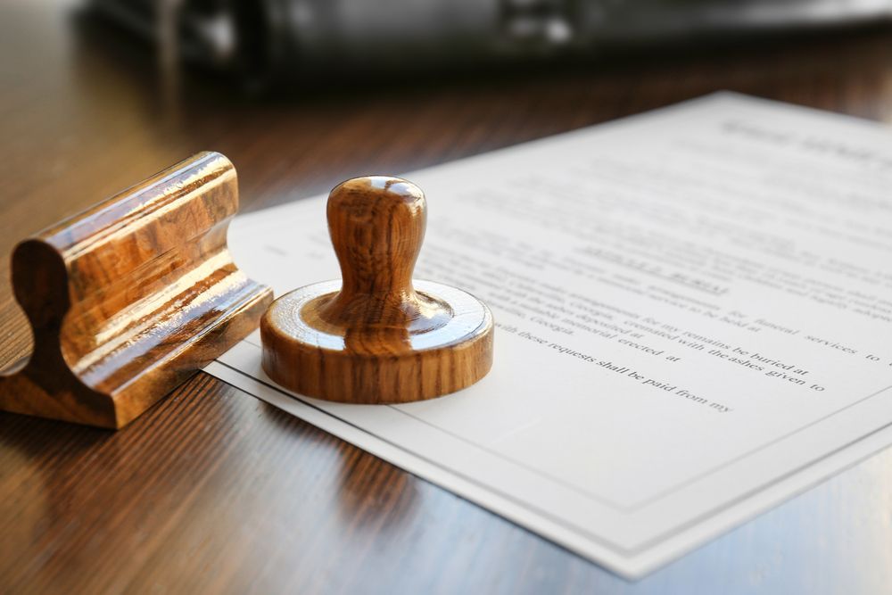 A wooden stamp is sitting on top of a piece of paper on a wooden table.