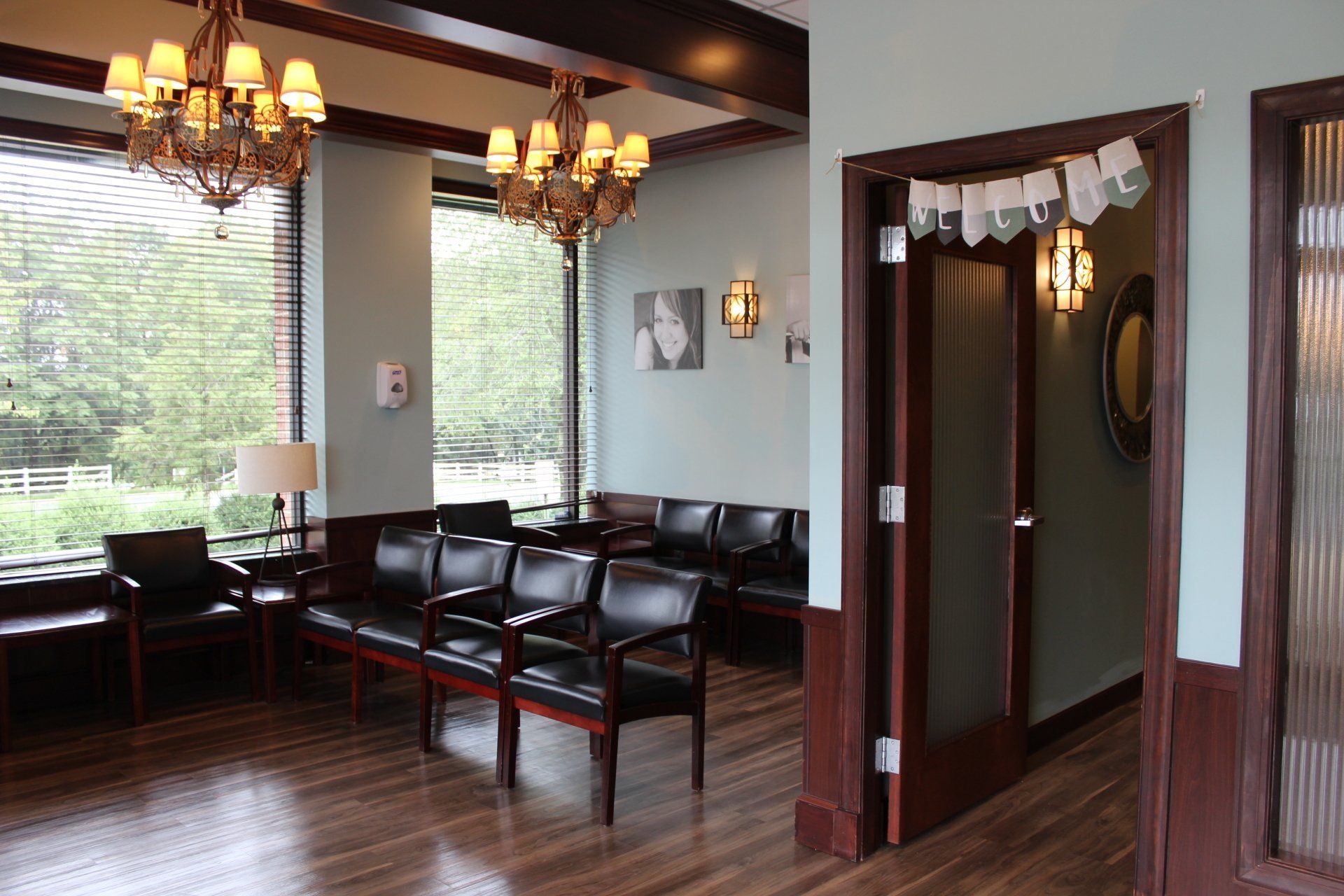 A waiting room with a lot of chairs and a chandelier.