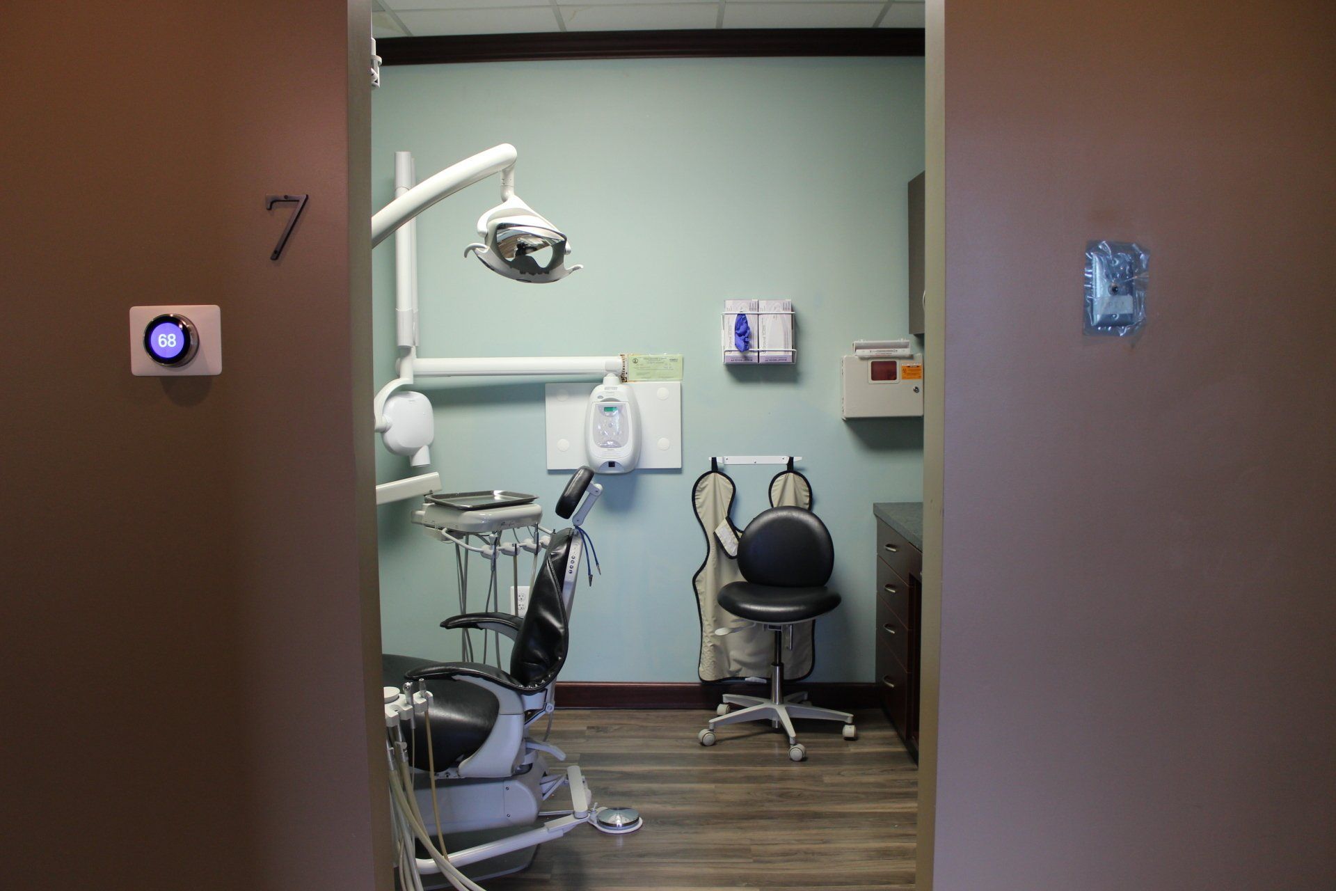 A dental office with a dental chair and a clock on the wall.