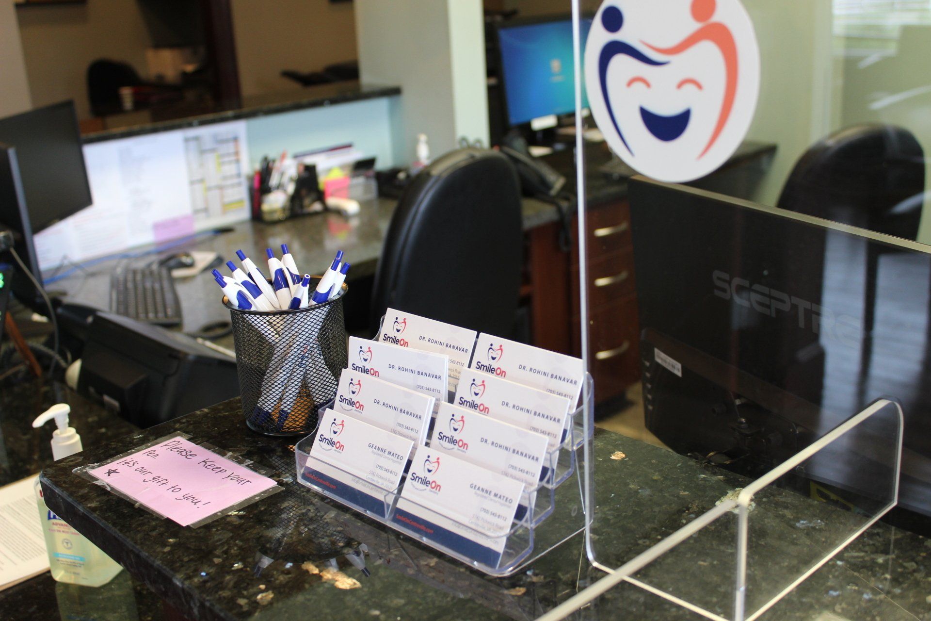 A display of business cards is on a counter in a dental office.
