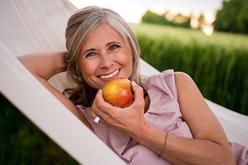 elder woman about to eat an apple