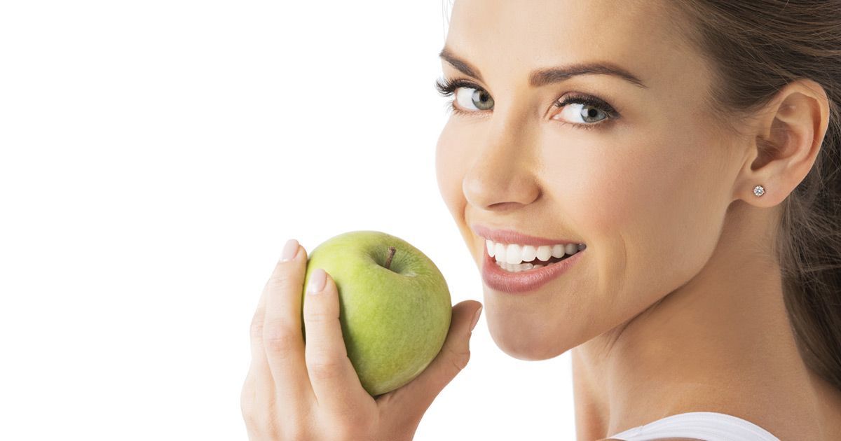 woman smiling with apple