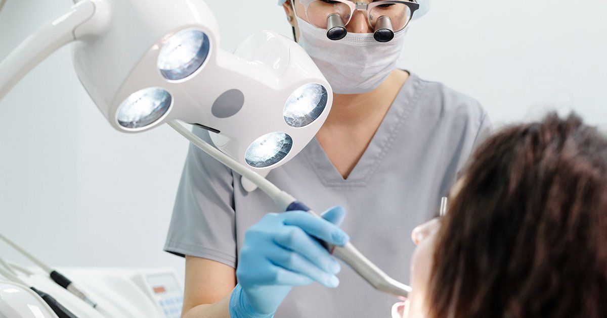patient under dental light with dentist