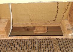 A wooden box with a hole in it is sitting on top of a carpet.