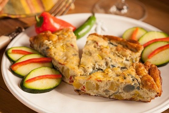 Slices of frittata served on a plate with vegetables