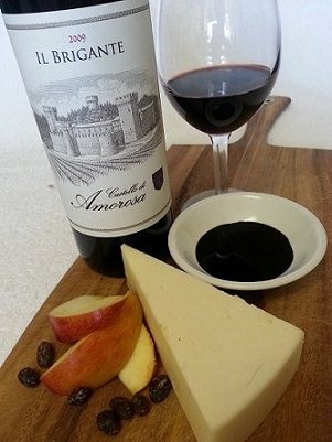 Wine bottle, cheese, apples, and charcuterie board