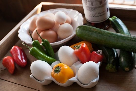 Fresh eggs, peppers, and zucchini arranged for cooking
