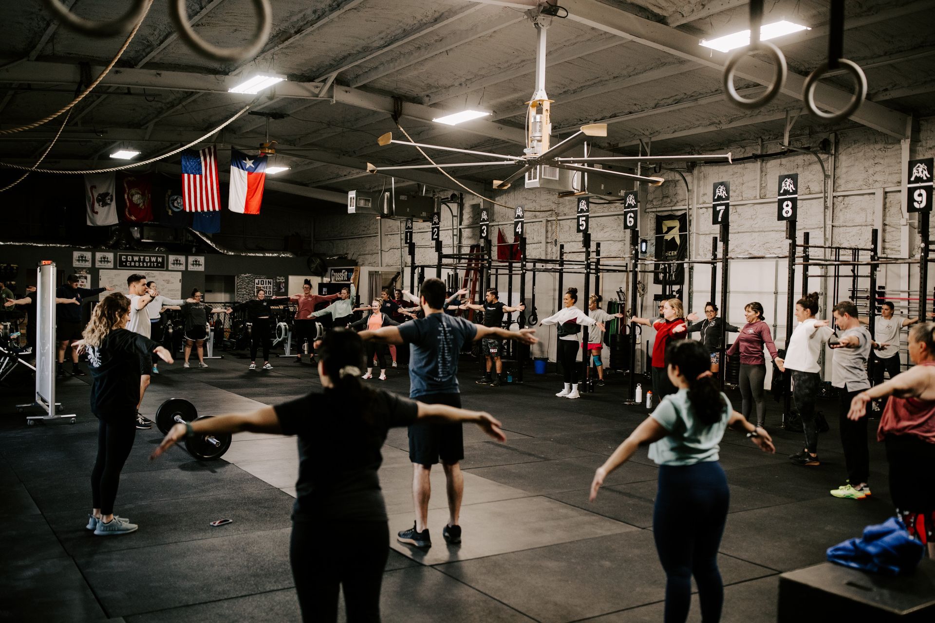 A group of people are doing stretching exercises in a gym.
