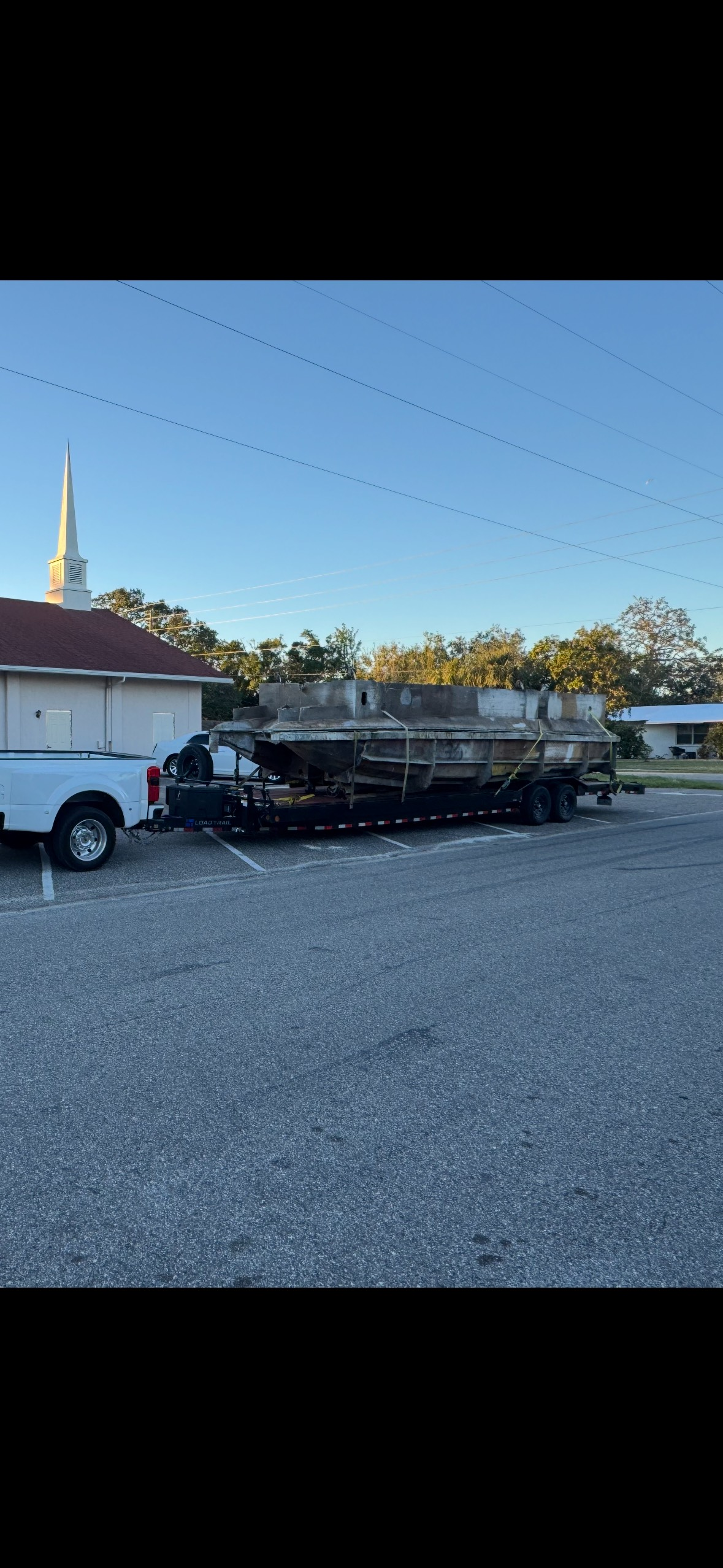 Black pickup truck bed loaded with two large boxes, secured with straps, parked outside a store. Black pickup truck bed loaded with two large boxes, secured with straps, parked outside a store.