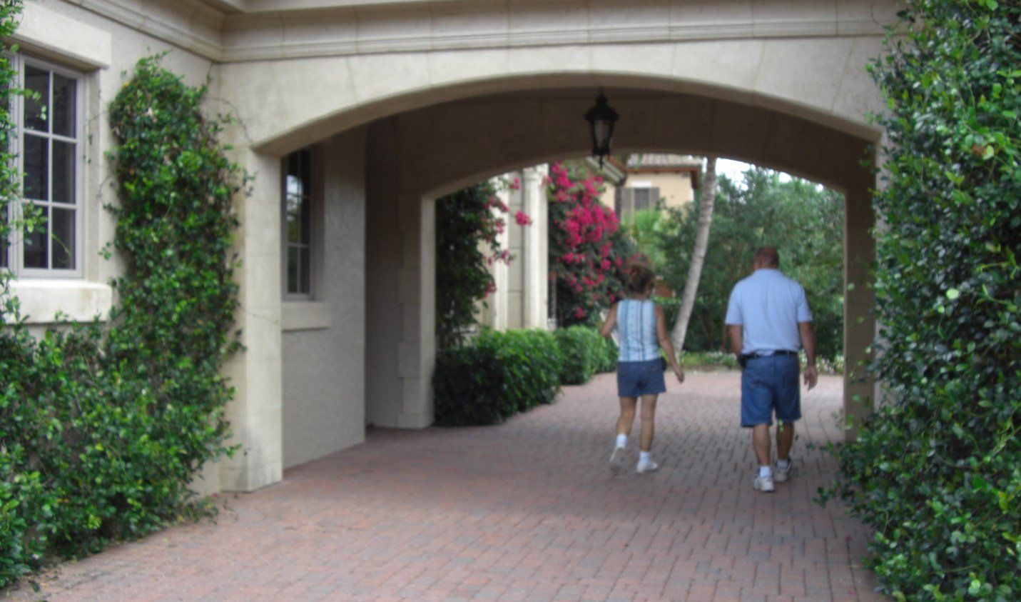 A man and a woman are walking under an archway.