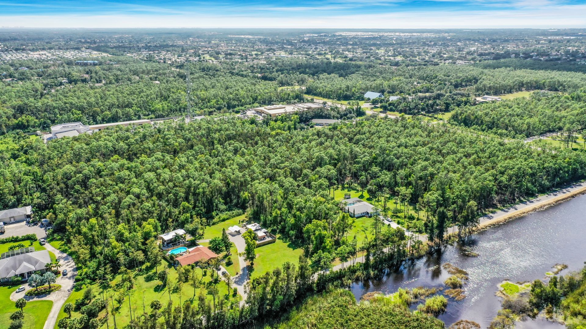 An aerial view of a residential area surrounded by trees and a lake — Naples, FL — Genuine Home Builders, Inc.