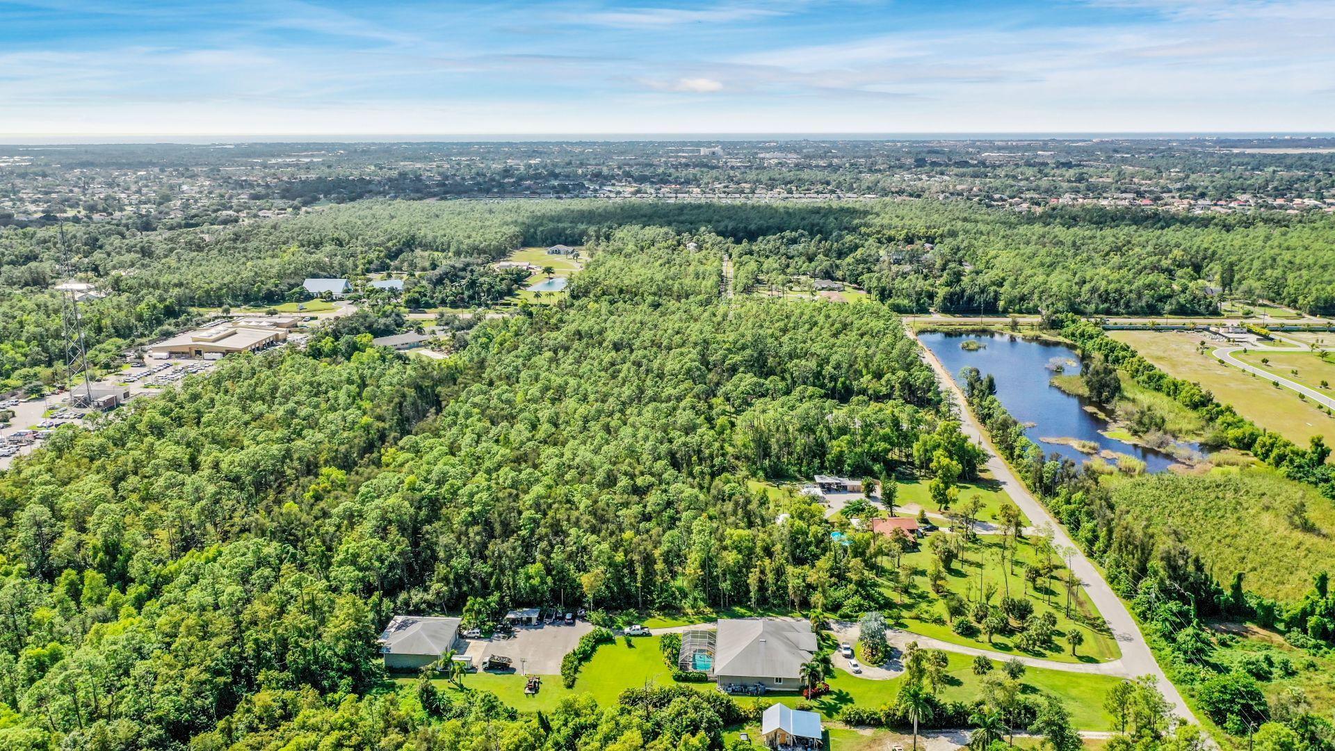 An aerial view of a residential area surrounded by trees and a lake — Naples, FL — Genuine Home Builders, Inc.