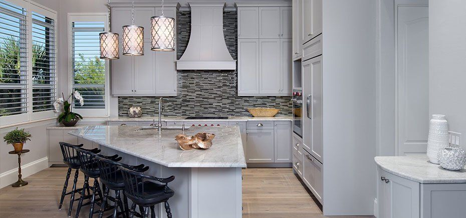 A kitchen with white cabinets, granite counter tops, stainless steel appliances.