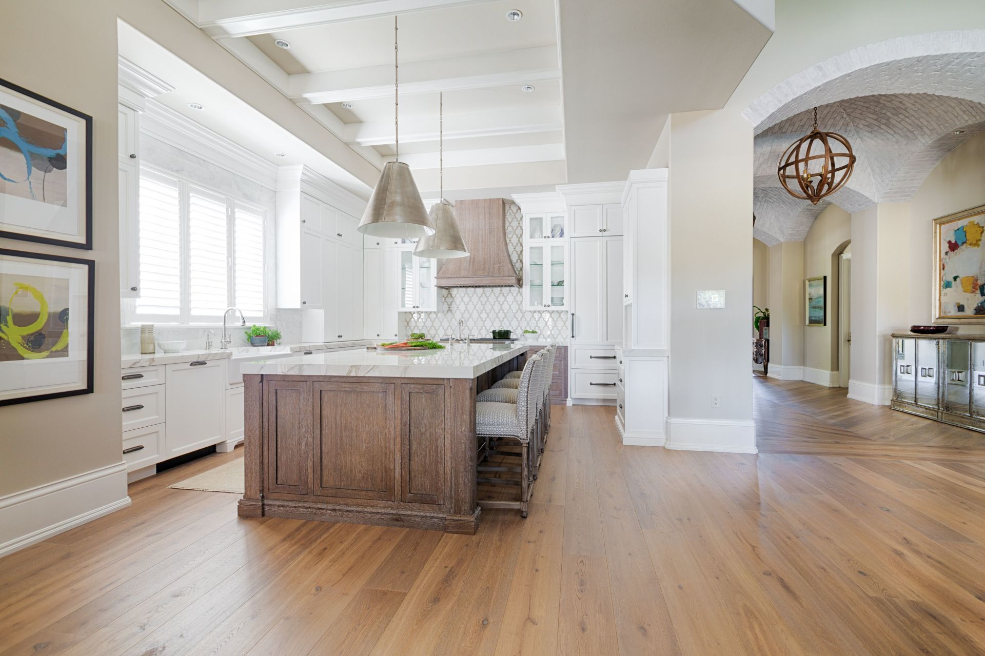 A kitchen with hardwood floors and a large island in the middle.