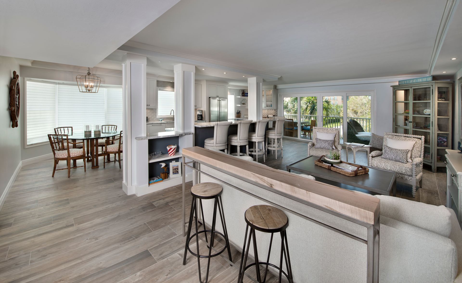 A living room with a couch, chairs, a table and stools.