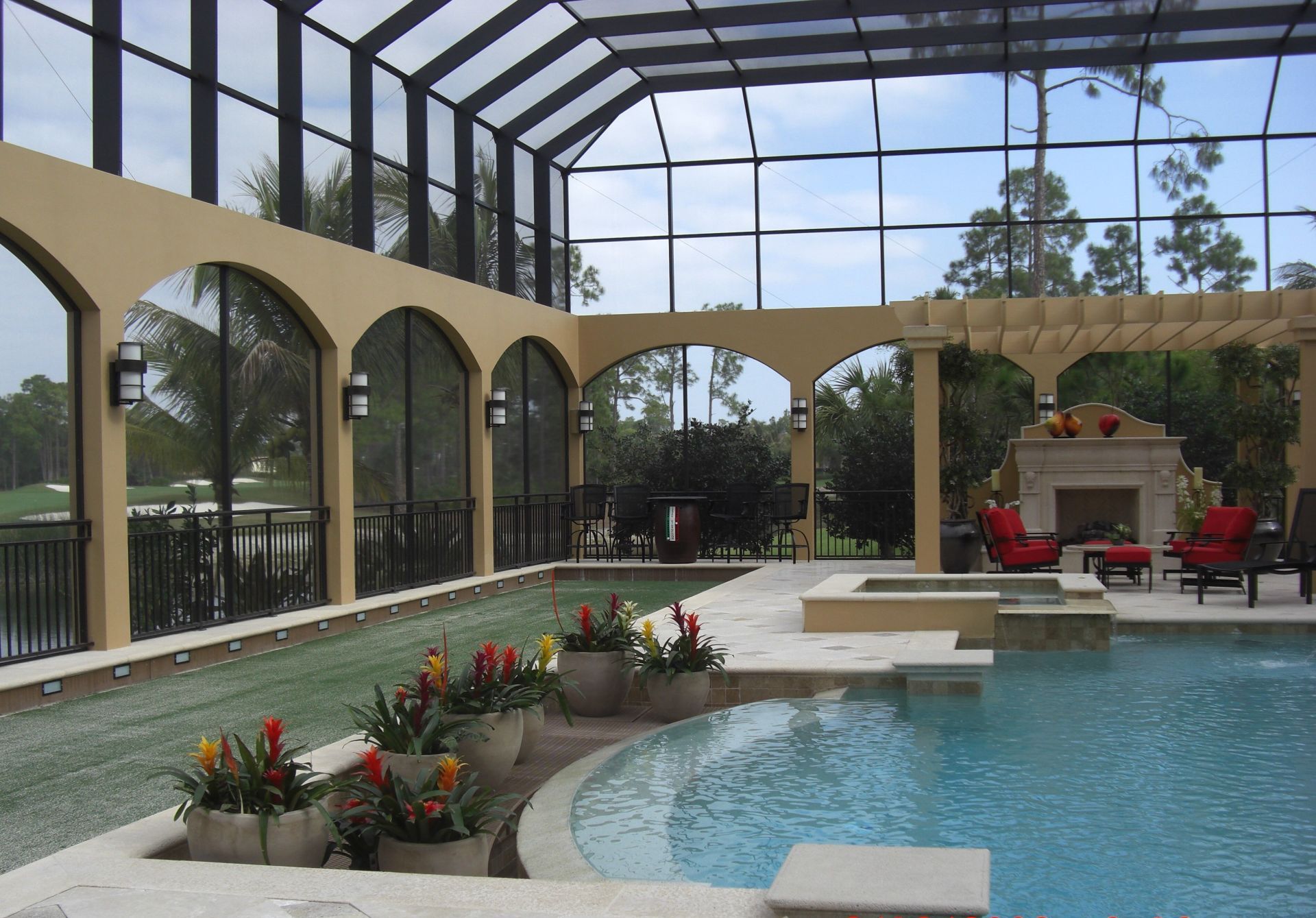 A large screened in swimming pool with a fireplace.
